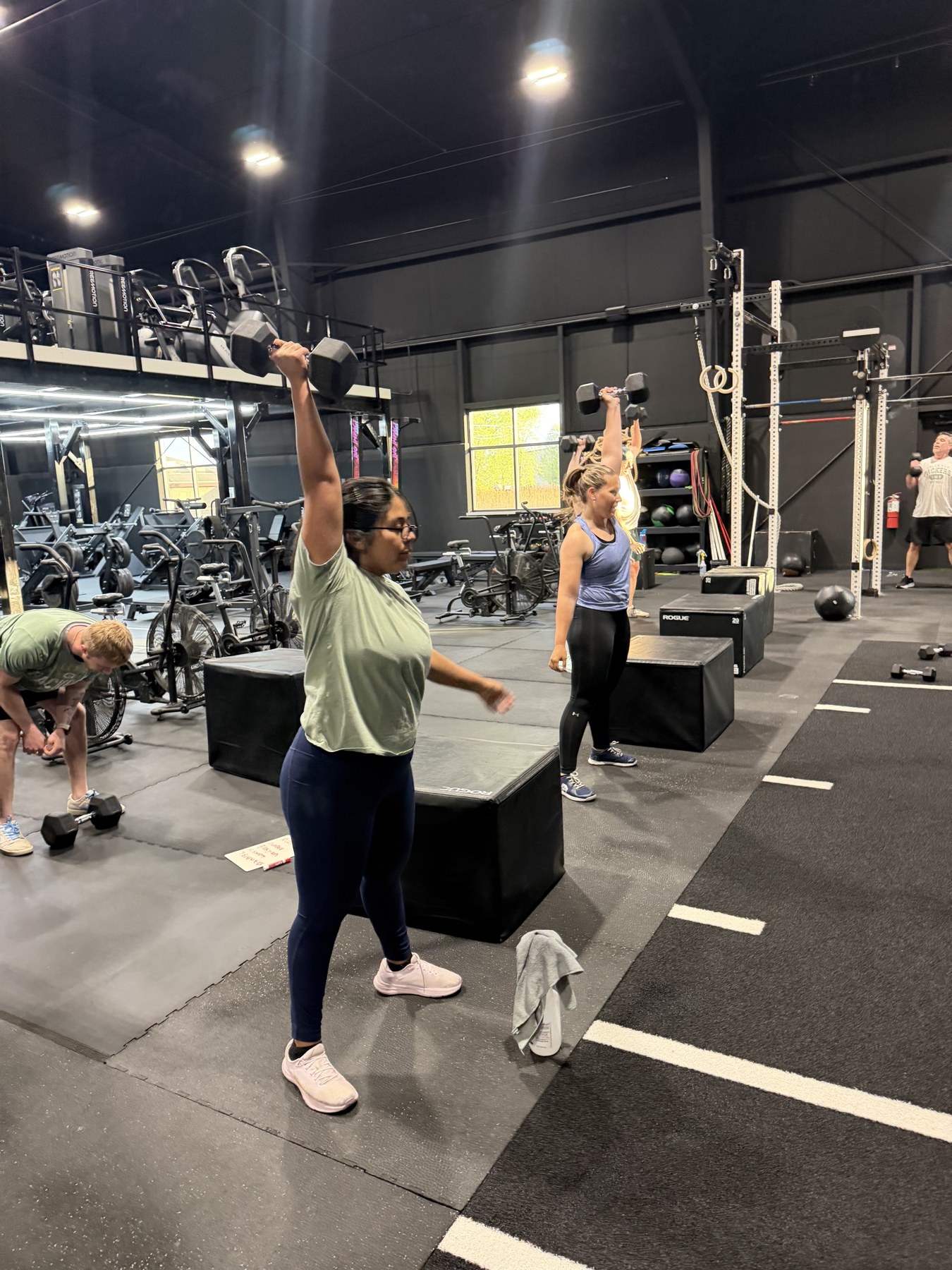 Coach guiding a member on the Iron Forge training floor