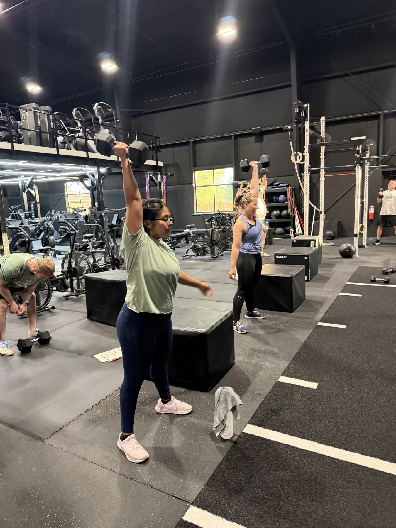 Members training with dumbbells on the Iron Forge gym floor